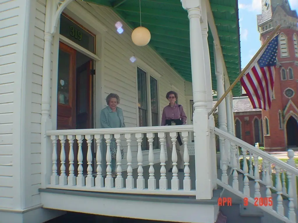 Two women pose for a photo in 2005 on the porch of a house built in 1879.
