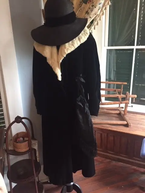 Early 1900s woman's fur-collared black coat and matching hat.